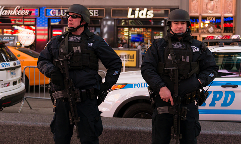 image ; two officers in business district with full riot gear