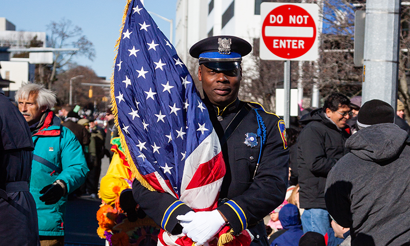 IMAGE of policeman with flag among the community